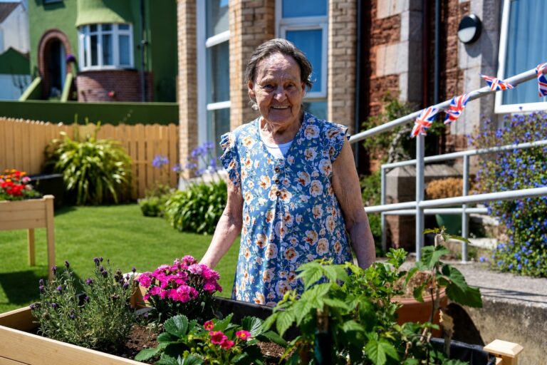 A warm moment between residents and staff in the garden at Kingsmount
