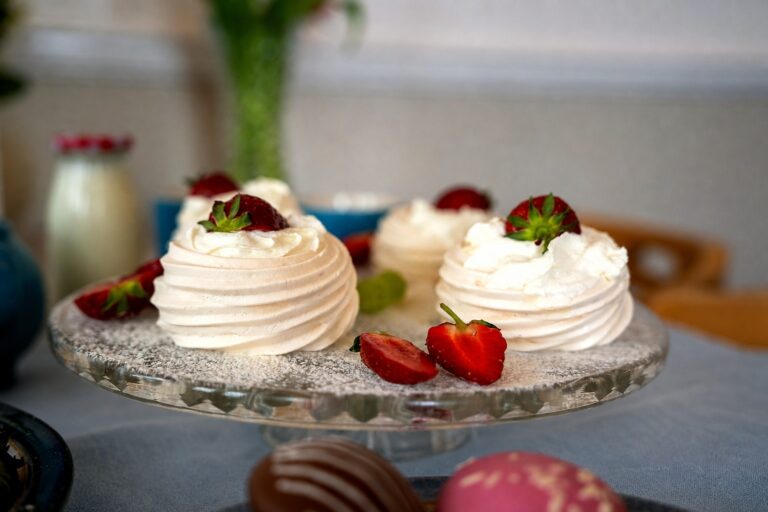 Mini pavlovas topped with cream and strawberries