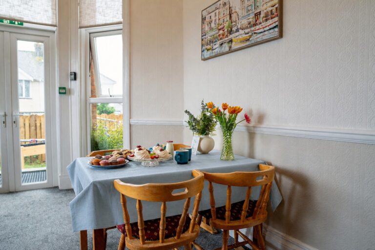 A dining table set with afternoon tea, overlooking the garden