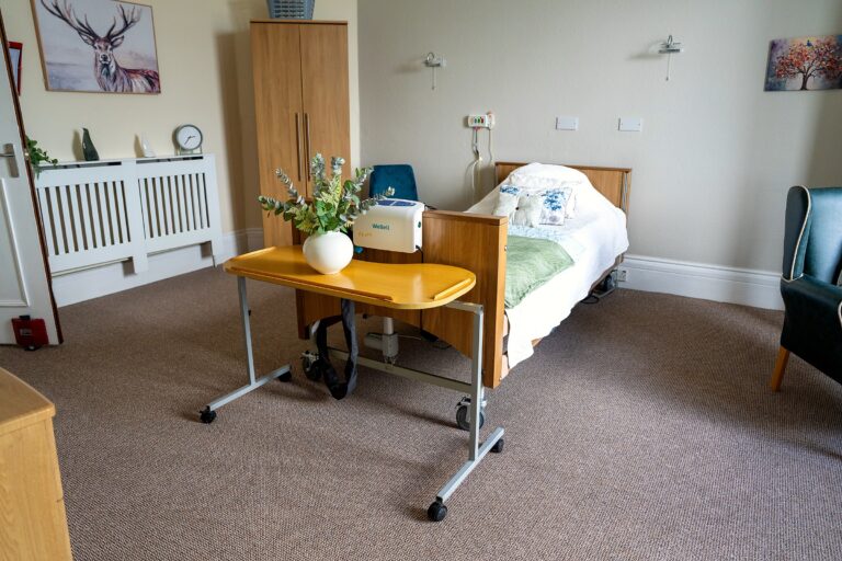 A resident's bedroom at Kingsmount with an adjustable bed and wardrobe