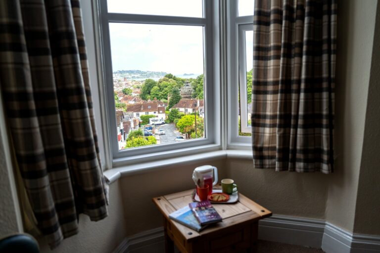 A bedroom window seat overlooking the street and Torbay beyond