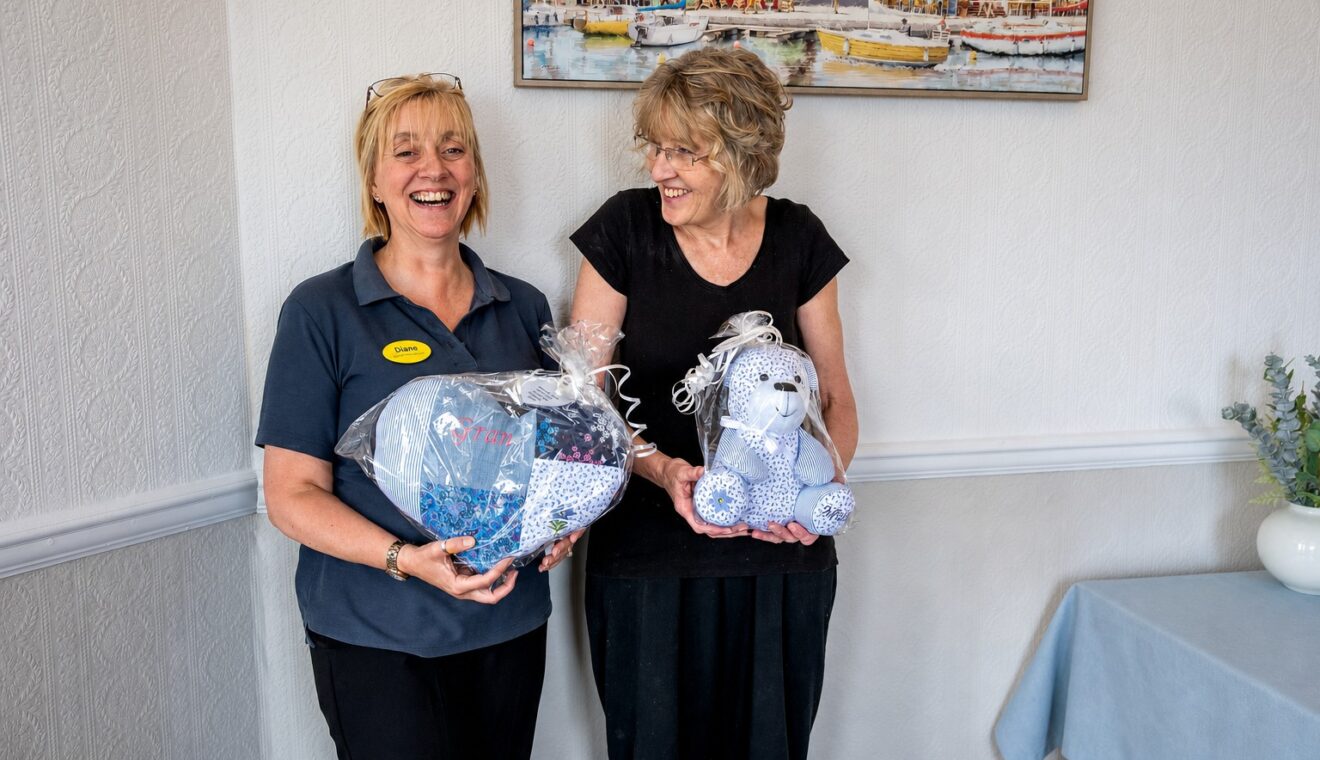 Staff members holding handmade memory keepsakes made for residents' families