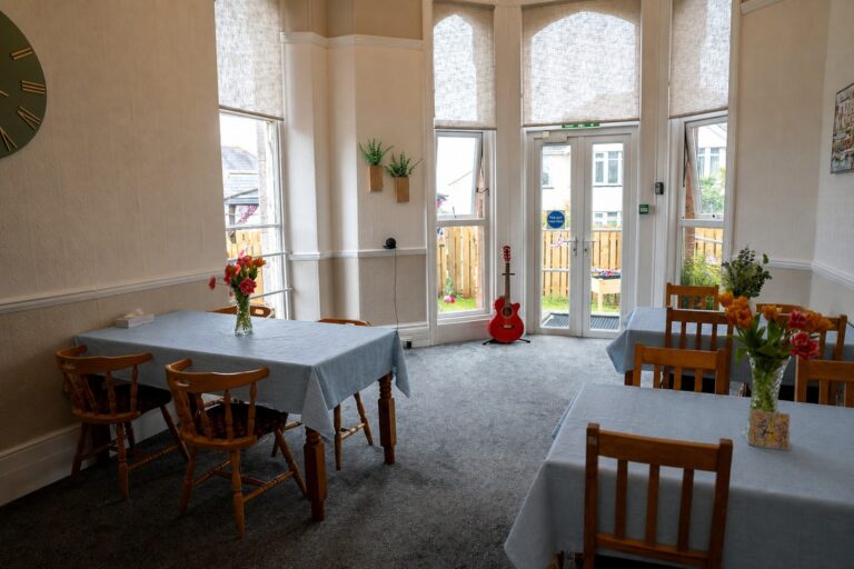 Kingsmount's dining room, set with blue tablecloths and fresh flowers