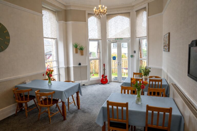 The grand dining room at Kingsmount, with a chandelier and garden doors
